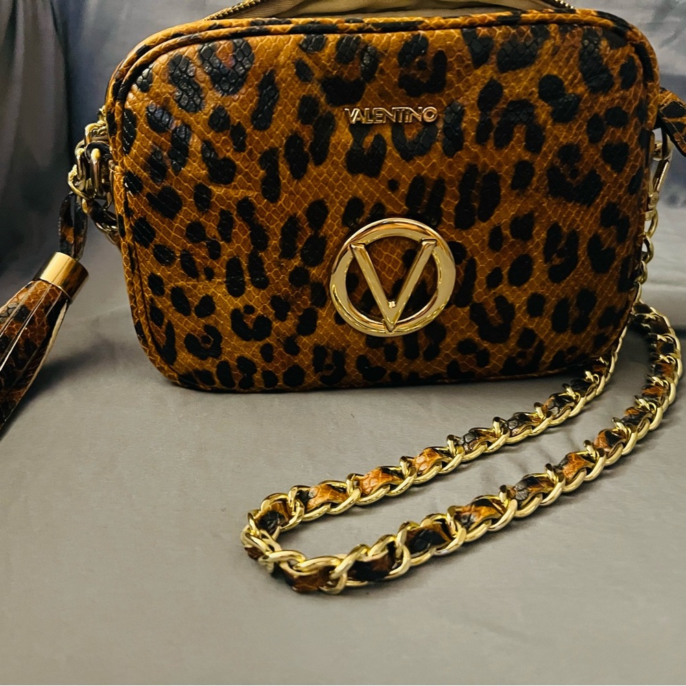 Made in Italy leather, this camera bag is styled with a metallic chain